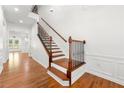 Bright foyer with hardwood floors, a staircase with wood and iron railings, and white trim at 3541 Ashcroft Se Dr, Smyrna, GA 30080