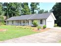 Cozy single-story home with a welcoming front porch and a well-manicured lawn and driveway at 5974 Sw Four Winds Sw Dr, Lilburn, GA 30047