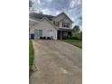 Charming two-story home featuring a well-manicured lawn and a long driveway leading up to the house at 6265 Gemstone Ct, South Fulton, GA 30349