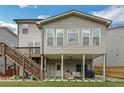 Rear elevation with deck, covered patio area with outdoor seating, and a well-maintained lawn at 935 Grove Valley Drive Dr, Cumming, GA 30041