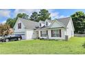 Inviting home with a lush lawn, dormer windows, and a black SUV parked in the driveway, showing curb appeal at 2233 Hansford Pass, Buford, GA 30519