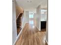 Inviting hallway with gleaming hardwood floors, staircase, and view into the living area and kitchen at 3948 Oak Glenn Dr, Duluth, GA 30096