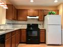 Functional kitchen featuring wood cabinets, black appliances, and ample counter space for meal preparation at 3948 Oak Glenn Dr, Duluth, GA 30096