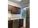 Bright kitchen featuring stainless steel appliances, brown cabinetry, granite countertops, and a window at 2479 Peachtree Ne Rd # 317, Atlanta, GA 30305