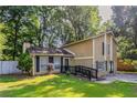 Charming two-story home featuring a well-manicured lawn, wood siding, and a welcoming front entrance with black railing at 5383 Forest East Ln, Stone Mountain, GA 30088