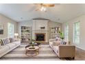 Cozy living room showcasing neutral furniture, a fireplace, decorative bookshelves, and ample natural light at 5383 Forest East Ln, Stone Mountain, GA 30088
