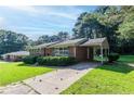 Inviting brick home featuring a carport and green, manicured landscaping at 573 Allgood Rd, Stone Mountain, GA 30083