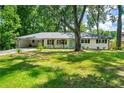 Charming single-story home with a lush green lawn and mature trees surrounding the property at 4103 Laynewood Cir, Tucker, GA 30084