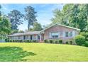 Classic brick home featuring a well-maintained lawn and mature trees, radiating timeless charm at 4581 Newcastle Cir, Lithonia, GA 30038