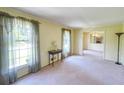 Bright living room with large windows, soft carpet, and neutral walls for versatile décor options at 4581 Newcastle Cir, Lithonia, GA 30038