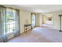 Bright living room with large windows, neutral carpet, and adjacent dining area at 4581 Newcastle Cir, Lithonia, GA 30038