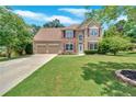 Charming two-story home with a well-manicured lawn, mature trees, and a two-car garage at 1002 Hallman Sw Ter, Marietta, GA 30064