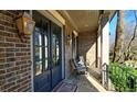 Cozy front porch with brick columns, lantern lighting, and seating for relaxing at 1600 Nottingham Ne Way, Atlanta, GA 30309