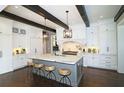 Spacious kitchen with large island, barstool seating, dark wood beams, and ample white cabinetry at 1600 Nottingham Ne Way, Atlanta, GA 30309