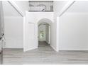 Bright foyer with soaring ceilings, gray wood floors, wainscoting, and an arched doorway, leading to the living spaces at 2023 Jameson Cir, Lawrenceville, GA 30043