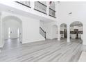Spacious living room with loft, staircase, gray wood floors, leading to entry, kitchen, and multiple rooms at 2023 Jameson Cir, Lawrenceville, GA 30043