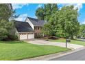 Traditional brick home with a two-car garage, surrounded by mature trees and a well-manicured lawn in a neighborhood at 2031 Greyfield Nw Dr, Kennesaw, GA 30152