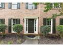 Inviting front entrance with a dark door, brick facade, and manicured landscaping, creating a warm welcome at 2031 Greyfield Nw Dr, Kennesaw, GA 30152