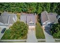 An aerial view displaying a home with mature landscaping, a driveway, and a two-car garage at 3485 Parkbrooke Ln, Duluth, GA 30096