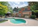 Beautiful backyard featuring a pool, brick patio, cabana, and well-maintained landscaping at 1006 Arbor Ne Trce, Atlanta, GA 30319
