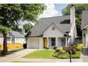Charming single-Gathering home with a yellow door, a well-manicured lawn, and an attached one-car garage at 1334 Gates Se Dr, Atlanta, GA 30316