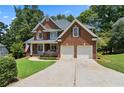 Traditional two-story brick home with an attached garage and well-maintained driveway at 2713 Misty Rock Cv, Dacula, GA 30019
