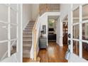 Inviting foyer with hardwood floors, staircase, and view into the living room at 2713 Misty Rock Cv, Dacula, GA 30019