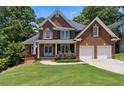 Beautiful brick home featuring an attached two-car garage and landscaped front yard at 2713 Misty Rock Cv, Dacula, GA 30019