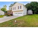 This charming home features a front porch, two-car garage, landscaped yard, and an outbuilding for extra storage at 421 River Trace Dr, Villa Rica, GA 30180