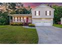 Charming two-story home with vinyl siding, a front porch, attached two-car garage, and a well-manicured front lawn at 421 River Trace Dr, Villa Rica, GA 30180