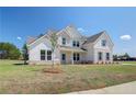 Inviting two-story home with brick and siding, complemented by blue shutters and a well-manicured lawn at 443 Lothbury Ave, Locust Grove, GA 30248