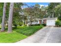 Quaint home featuring a long driveway flanked by mature trees and manicured lawn at 1959 Audubon Ne Dr, Atlanta, GA 30329