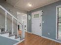Welcoming foyer with hardwood floors, a staircase, and a bright white front door with sidelight windows at 21 Queen Anne Se Dr, Mableton, GA 30126