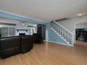 Open-concept living room with hardwood floors, a fireplace, and a staircase with access to a study at 21 Queen Anne Se Dr, Mableton, GA 30126