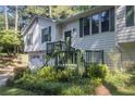 Split level home with green trim features mature landscaping and an attached two-car garage at 1180 Springs Dr, Canton, GA 30115