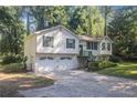 Traditional split level home shows white siding, green shutters, manicured lawn, and an attached two-car garage at 1180 Springs Dr, Canton, GA 30115