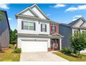 Inviting two-story home with an attached garage, well-manicured lawn, and charming curb appeal on a sunny day at 2859 Woodward Down Trl, Buford, GA 30519