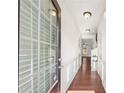 Bright hallway featuring hardwood floors, white trim, and a glass front door, leading into the living area at 2859 Woodward Down Trl, Buford, GA 30519