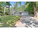 Charming two-story home with a long driveway and a lush, green front lawn surrounded by mature trees at 431 Hickory Se Ln, Smyrna, GA 30082