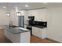 Bright kitchen boasts white cabinets, stainless appliances, black backsplash, and a marble island at 1092 Hillcrest Se Dr, Atlanta, GA 30316