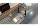 Close up of sink with pull-down sprayer and elegant marble counter in renovated kitchen at 1092 Hillcrest Se Dr, Atlanta, GA 30316