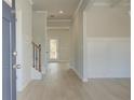 Bright entryway with hardwood floors, white wainscoting, and a staircase with decorative iron spindles at 117 Compass Rd, Hampton, GA 30228