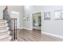 Elegant foyer with wood flooring and staircase, offering a view into the home office space with lots of natural light at 2115 Bentbrooke Trl, Lawrenceville, GA 30043