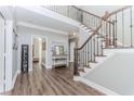 Inviting foyer with wood flooring, a staircase with wrought iron railings, and bright, neutral walls at 2115 Bentbrooke Trl, Lawrenceville, GA 30043