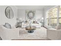 Bright living room featuring neutral decor, stylish furnishings, and a large window with backyard views at 2241 Chaseford Ln, Powder Springs, GA 30127
