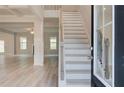 Bright foyer boasts hardwood floors, white trim, a staircase with a dark railing, and views of living spaces at 428 Hatcher Ct, Hampton, GA 30228