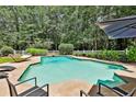 Inviting backyard pool area with clear water, lounge chairs, and a serene setting surrounded by trees at 140 Silvermere, Fayetteville, GA 30215