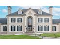 Elegant two-story home featuring arched windows, decorative shutters, and a meticulously maintained lawn at 1806 Wynthrop Manor Sw Dr, Marietta, GA 30064