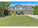 Inviting two-story home with manicured lawn, covered porch, and attached two-car garage at 204 Sawtooth Ct, Canton, GA 30114