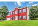 Charming two-story red brick home with a well-manicured lawn and a two-car garage at 1029 Chaterly Ct, Riverdale, GA 30296